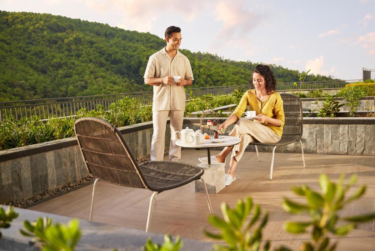 a man and a woman sitting on a roof at Hyatt Regency Dehradun Resort and Spa in Dehradun