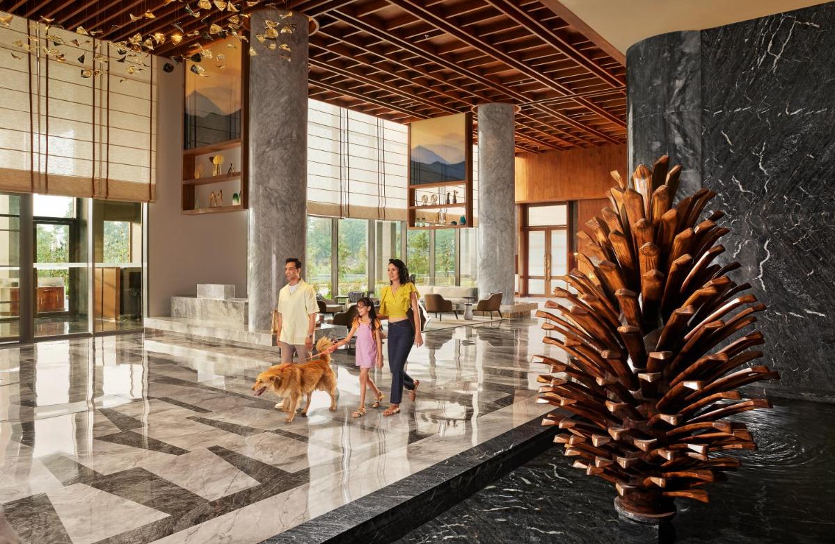a family walking with a dog in a lobby at Hyatt Regency Dehradun Resort and Spa in Dehradun