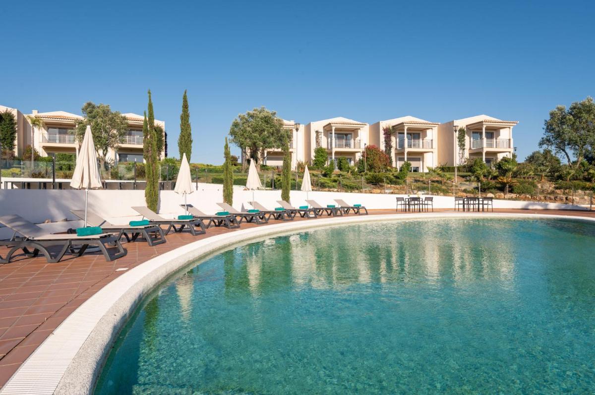 uma piscina com cadeiras e guarda-sóis em um resort em Vale da Lapa Village Resort em Carvoeiro mais 72 fotografias
