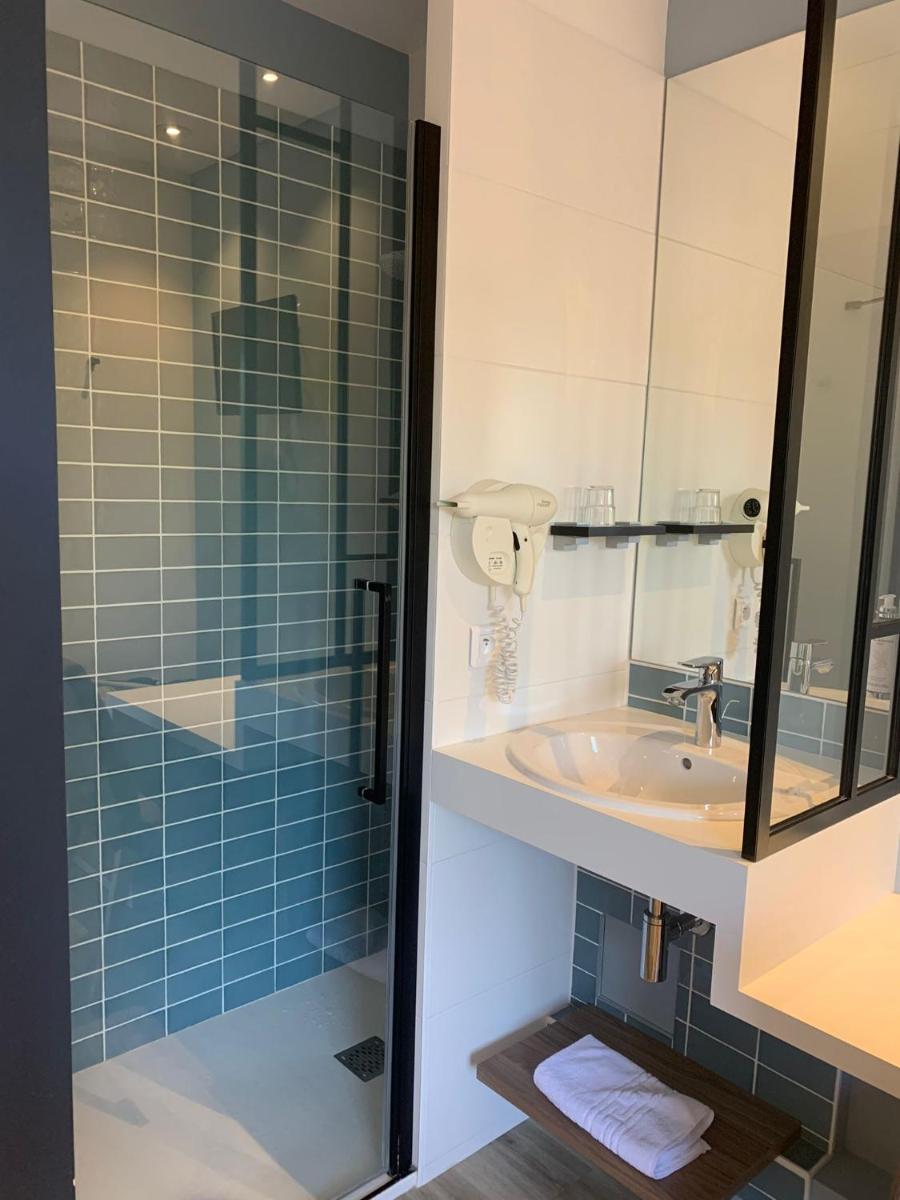 une salle de bains avec lavabo et douche en verre dans l'établissement Logis Hôtel Domaine du Moulin Cavier - Restaurants & Spa, à Avrillé 118 autres photos