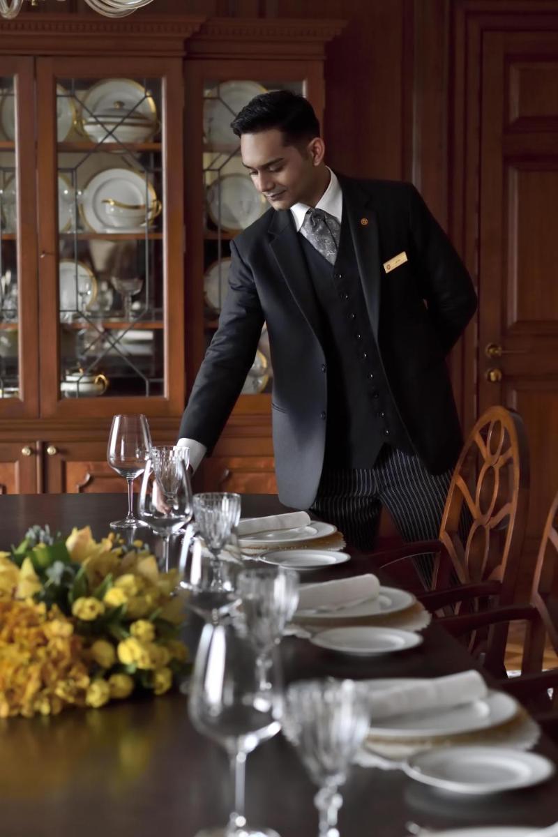 a man in a tuxedo standing at a table with glasses at Taj Mahal, New Delhi in New Delhi
