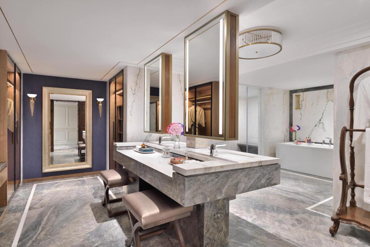 a bathroom with a large marble sink and mirrors at Taj Mahal, New Delhi in New Delhi