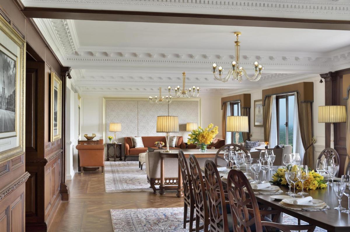 a dining room with a table and a living room at Taj Mahal, New Delhi in New Delhi