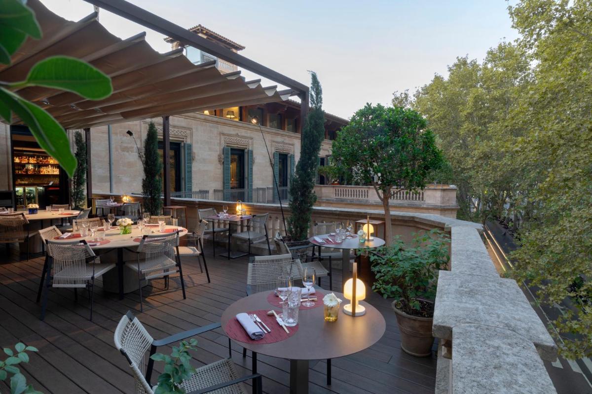 una zona de comedor al aire libre con mesas y sillas en una terraza en Hotel Can Alomar, en Palma de Mallorca