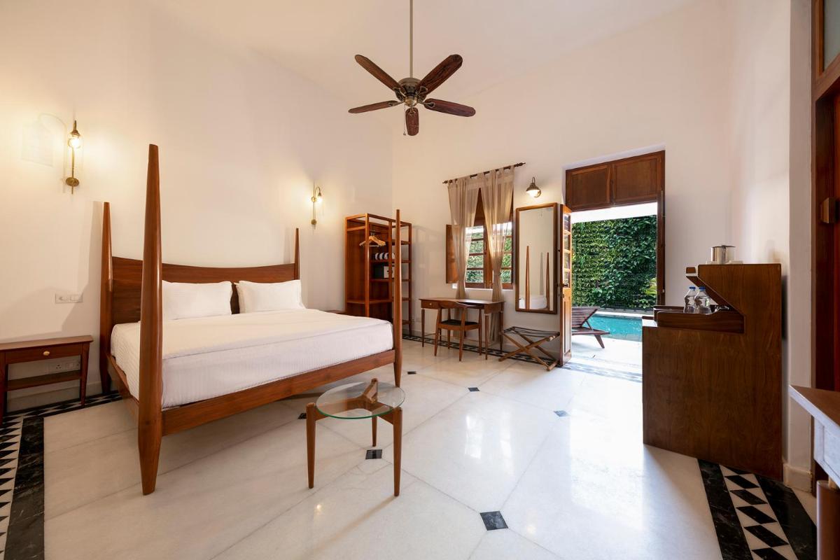 a bedroom with a bed and a ceiling fan at Grand Hotel D'Europe in Puducherry