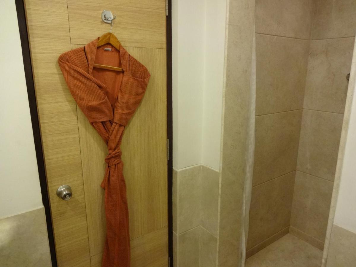 a robe hanging on a door next to a shower at Lemon Tree Premier Hitec City Hyderabad in Hyderabad