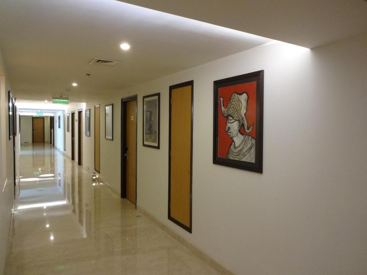 a hallway in a hospital with paintings on the walls at Lemon Tree Premier Hitec City Hyderabad in Hyderabad