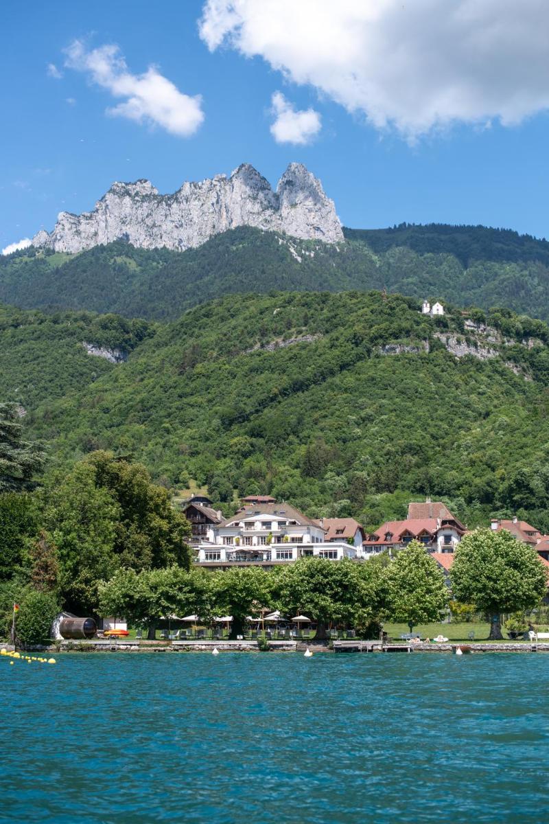 un village au bord d'un lac avec des montagnes dans l'établissement Hôtel Beau Site Talloires B SPA, à Talloires
