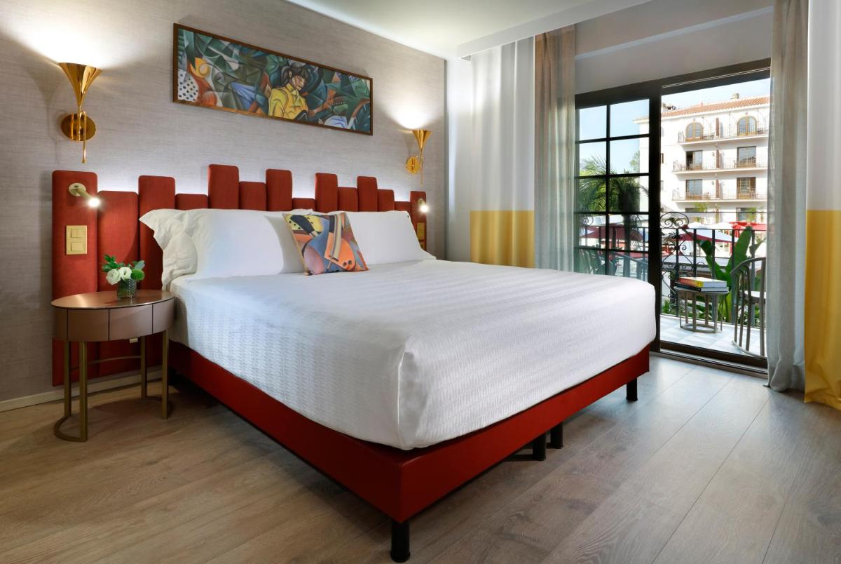 Un dormitorio con una cama grande y un balcón. en Hard Rock Hotel Marbella - Puerto Banús, en Marbella