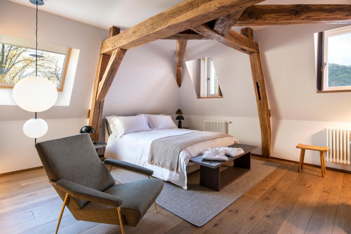 une chambre avec un lit et une chaise dans l'établissement Chateau de Wallerand, à Vireux-Wallerand