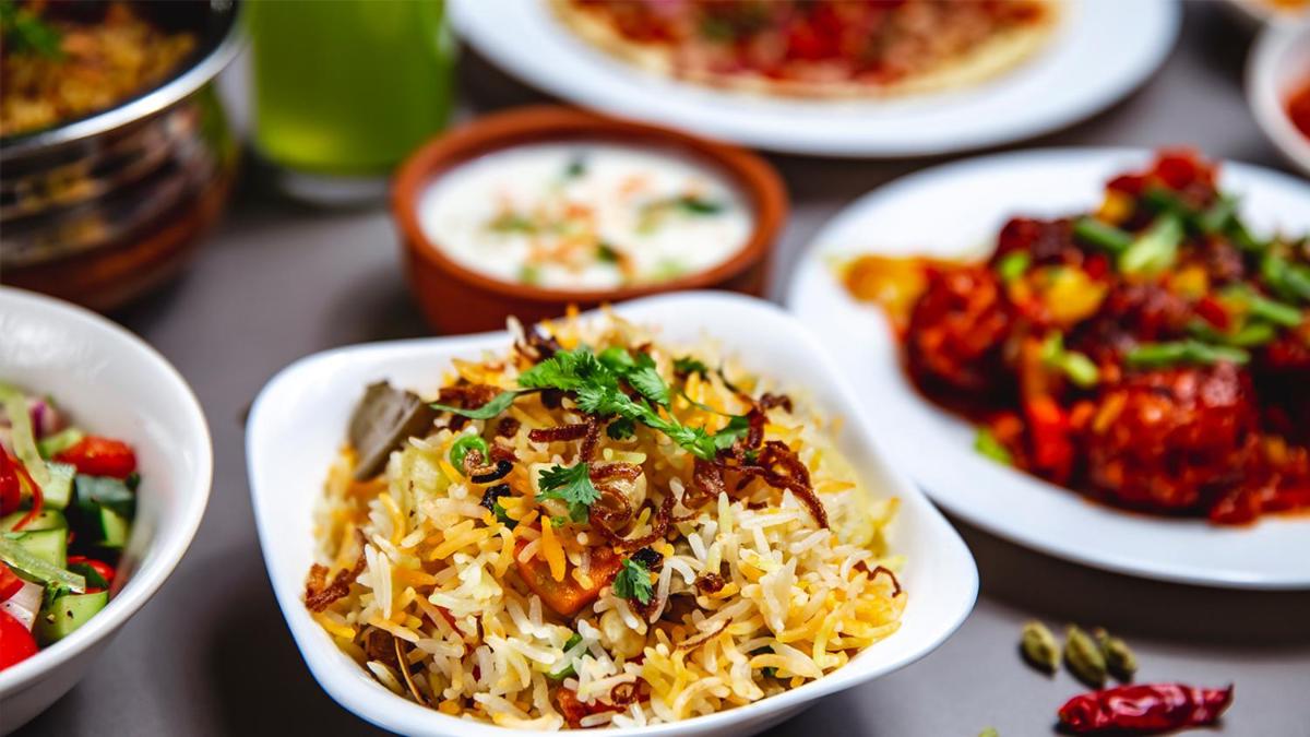a table topped with plates of food with rice and vegetables at Holiday Inn Chennai OMR IT Expressway by IHG in Chennai