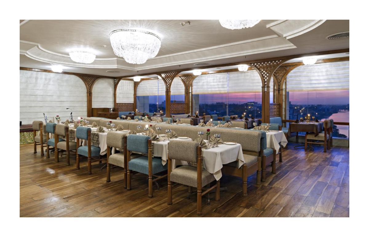 a dining room with tables and chairs with a view at Clarks Avadh in Lucknow