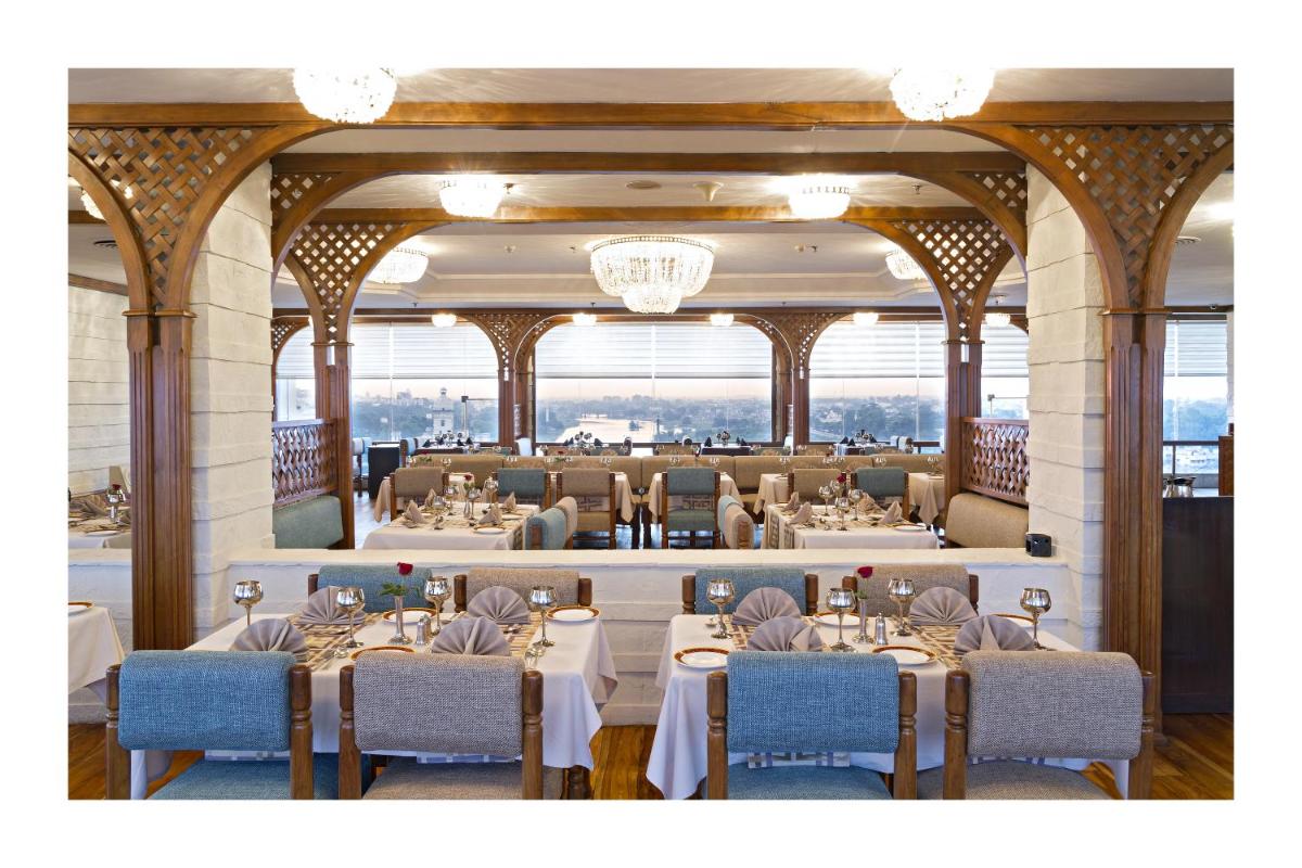 a restaurant with tables and chairs in a room at Clarks Avadh in Lucknow