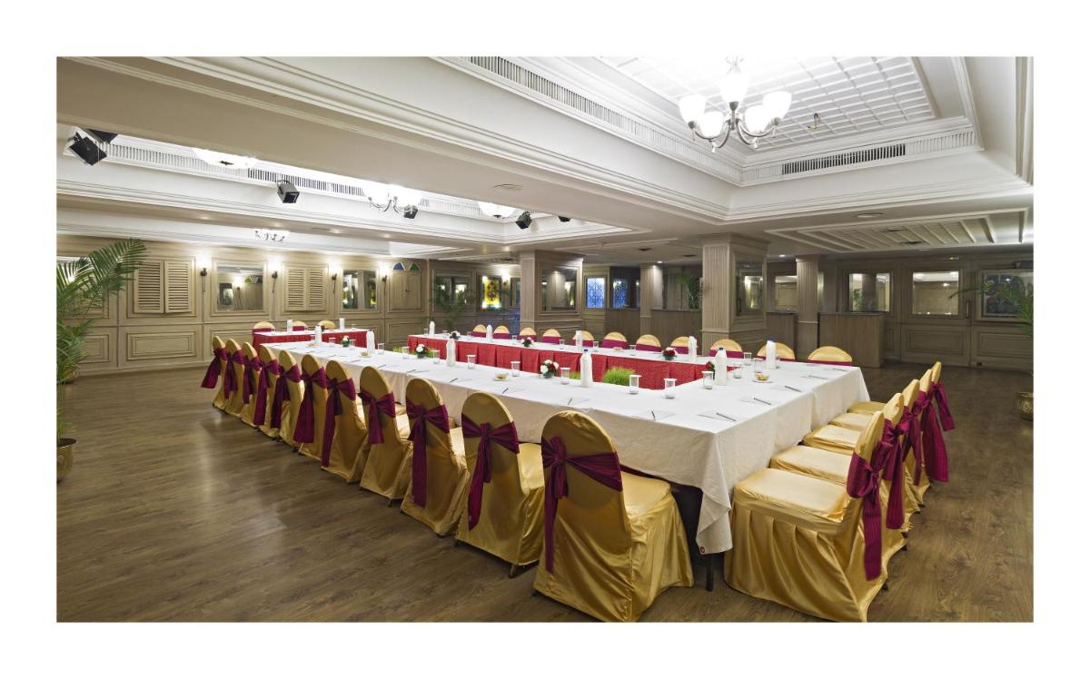 a conference room with a long table with yellow and red chairs at Clarks Avadh in Lucknow