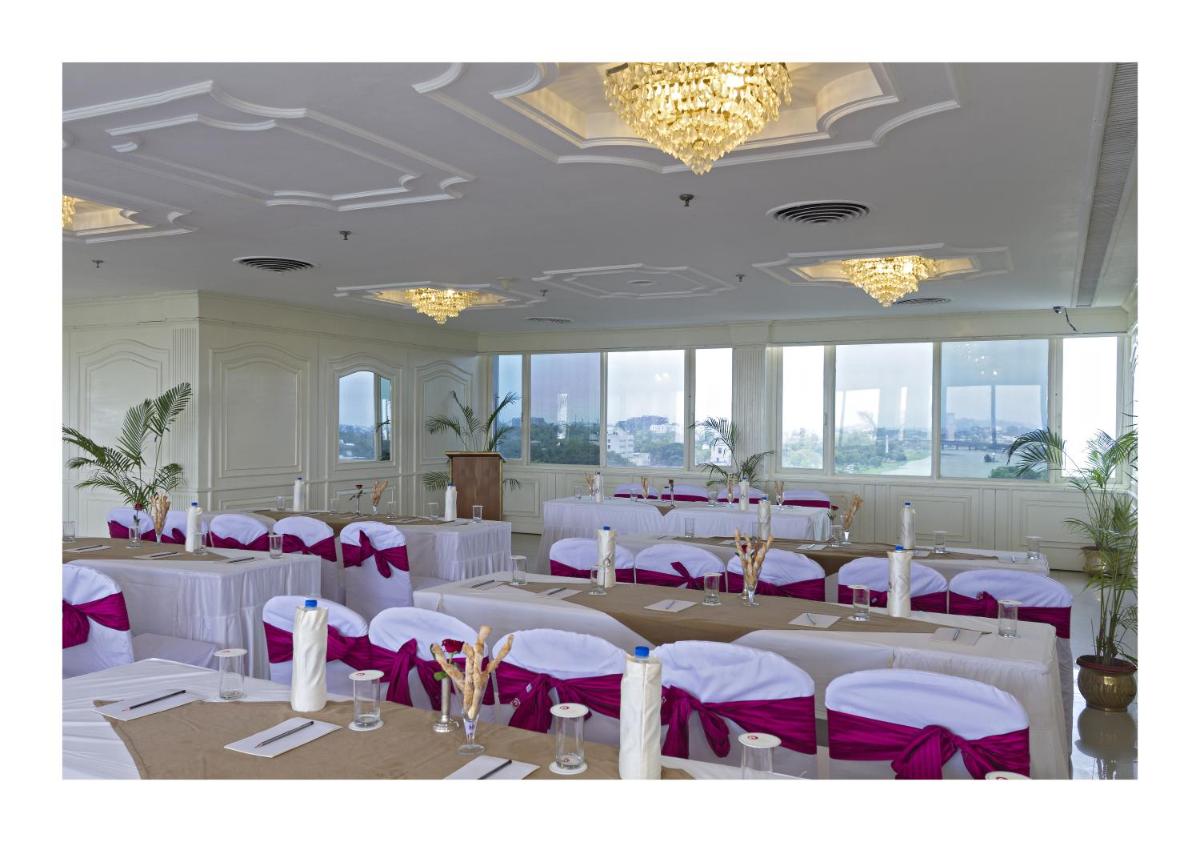 a banquet hall with white tables and purple chairs at Clarks Avadh in Lucknow