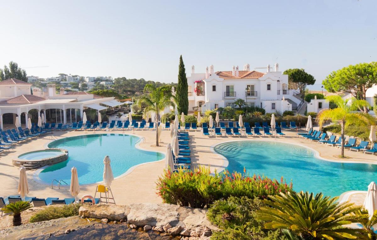 um resort com uma grande piscina com água azul em Dunas Douradas Beach Club no Vale do Lobo