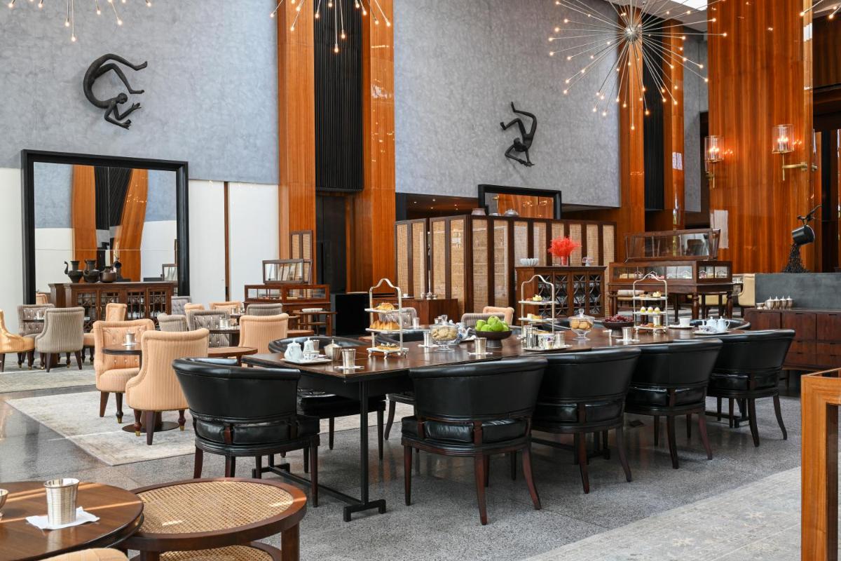 a dining room with a large table and chairs at Grand Hyatt Gurgaon in Gurgaon