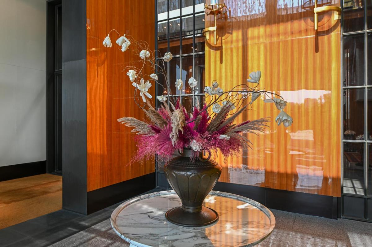 a vase with flowers sitting on a glass table at Grand Hyatt Gurgaon in Gurgaon