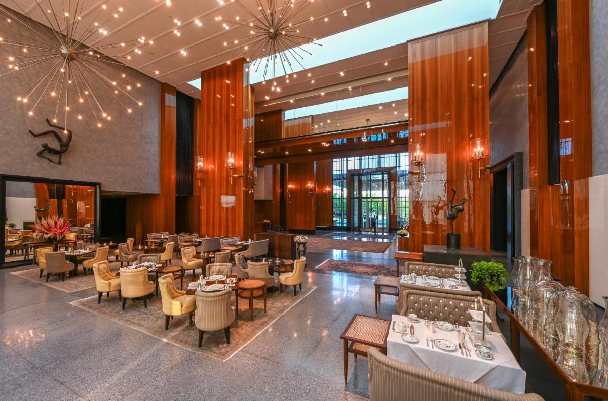 a restaurant with tables and chairs in a building at Grand Hyatt Gurgaon in Gurgaon