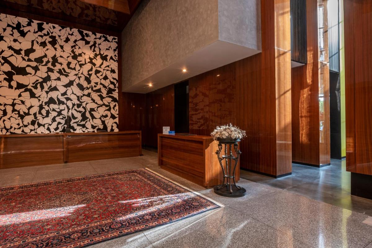a lobby with a vase of flowers on a rug at Grand Hyatt Gurgaon in Gurgaon