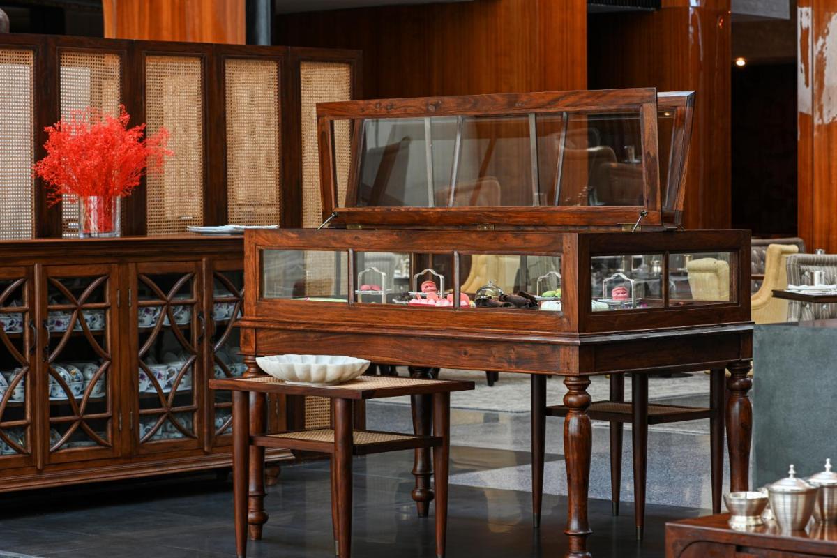 a wooden cabinet with a table and a stool at Grand Hyatt Gurgaon in Gurgaon