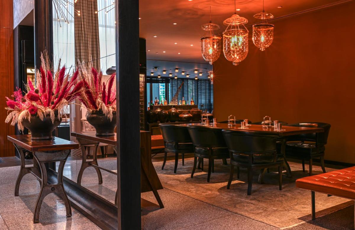 a restaurant with a table and chairs and chandeliers at Grand Hyatt Gurgaon in Gurgaon