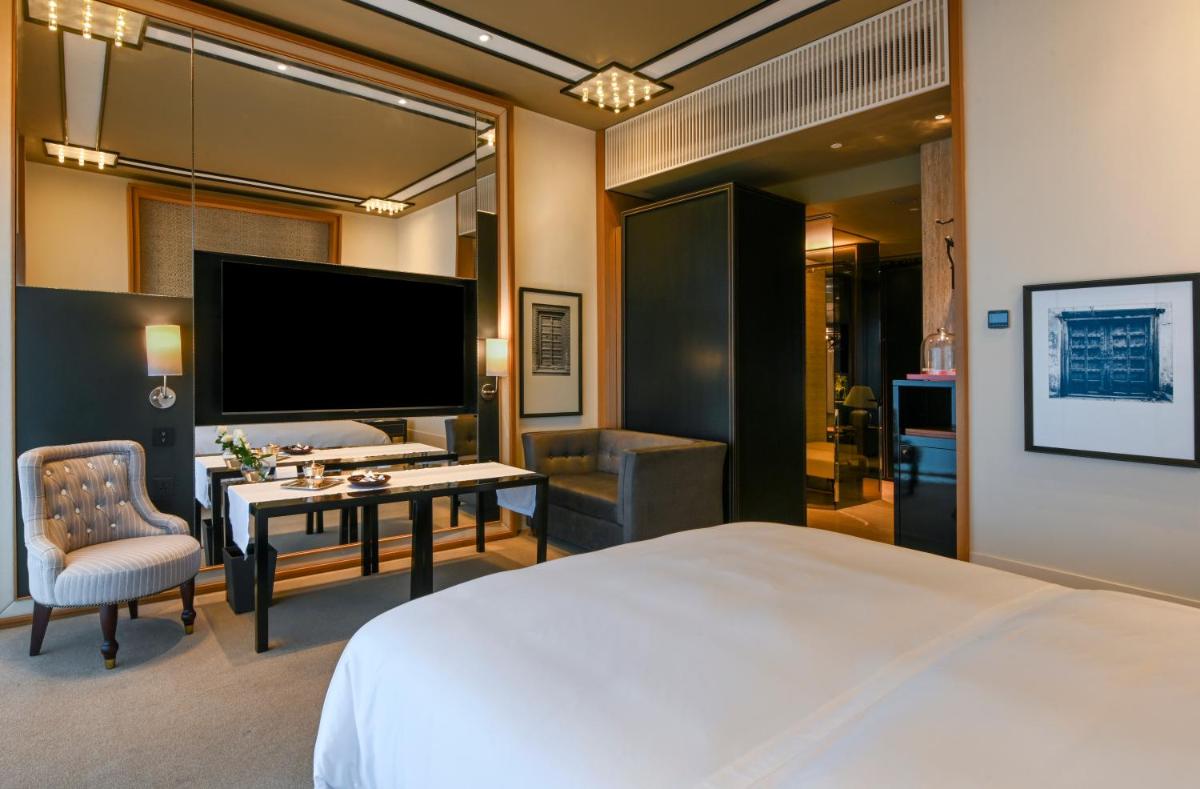 a hotel room with a bed and a desk and a television at Grand Hyatt Gurgaon in Gurgaon