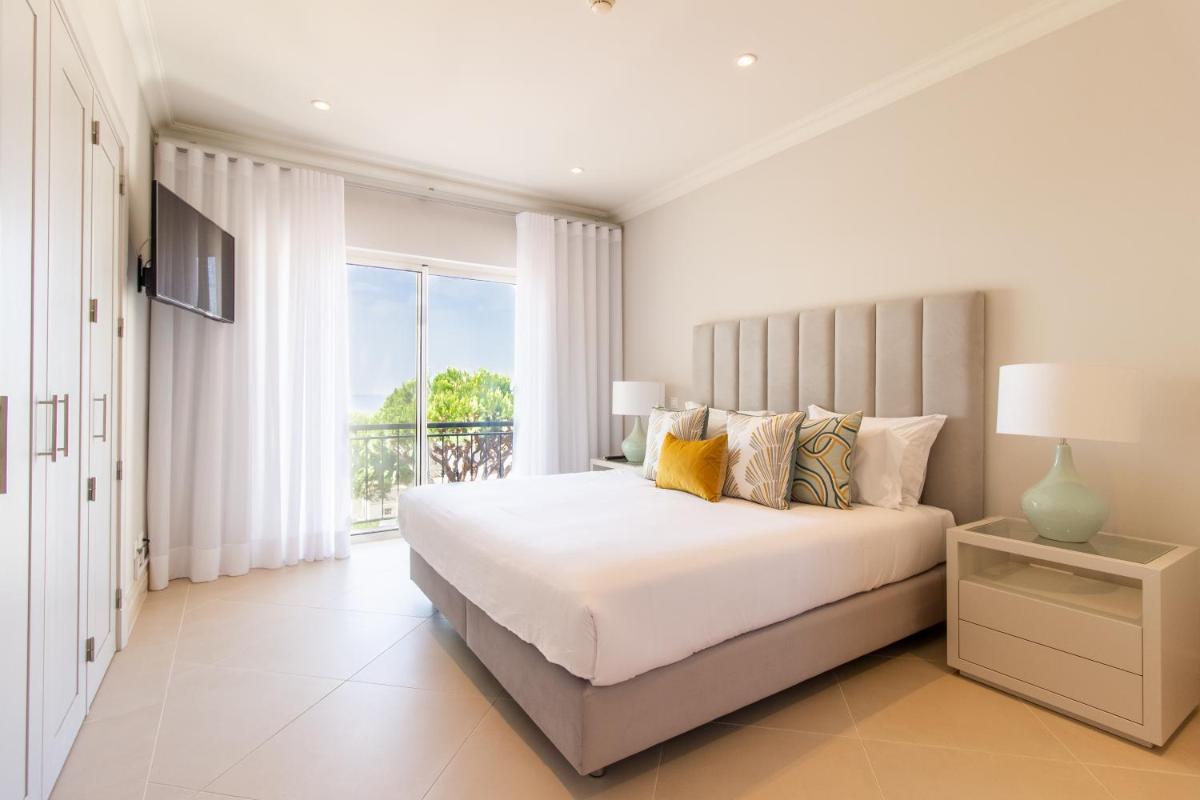 um quarto branco com uma cama grande e uma janela em Dunas Douradas Beach Club no Vale do Lobo mais 100 fotografias