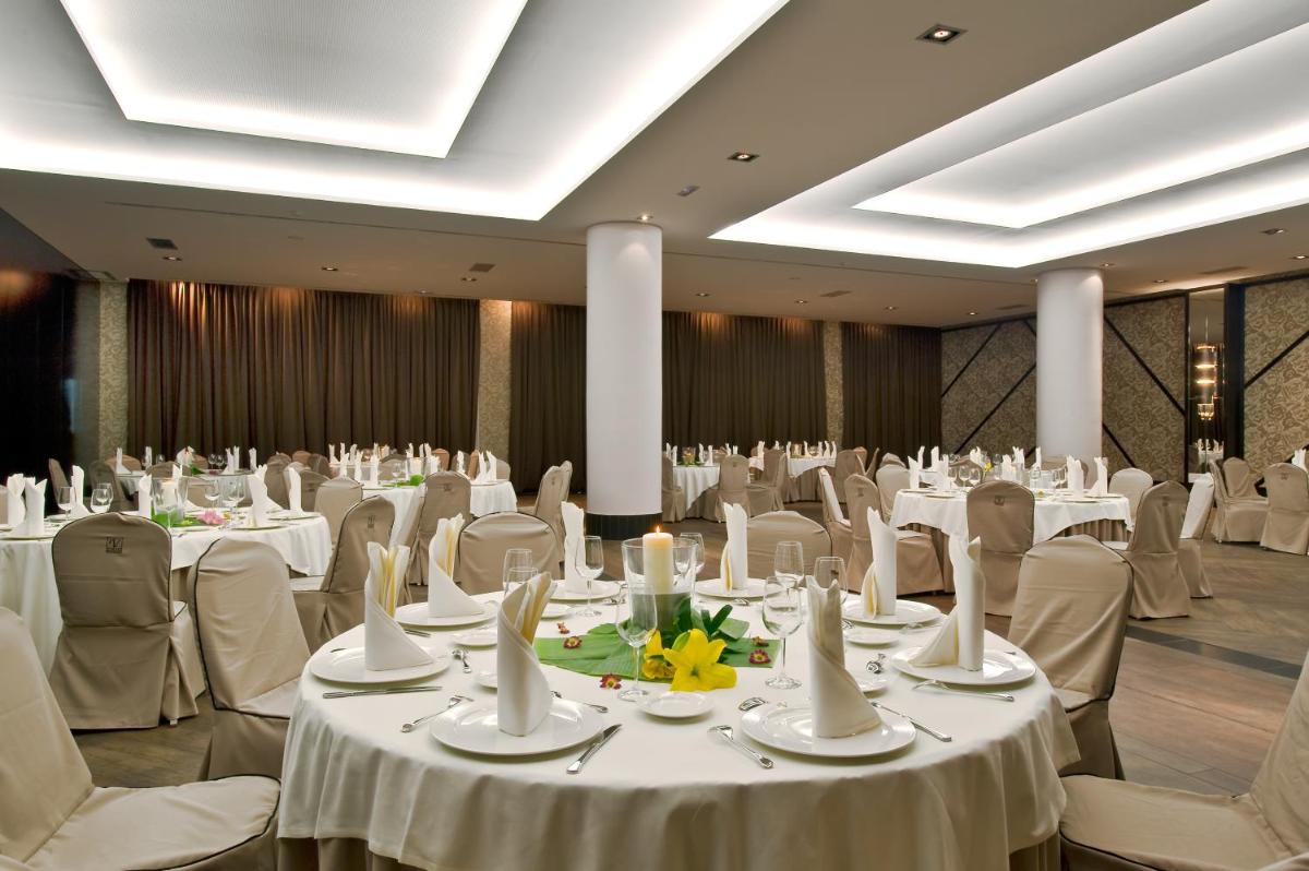 Un salón de banquetes con mesas y sillas blancas. en URH Hotel Spa Zen Balagares, en Overo 76 fotos más
