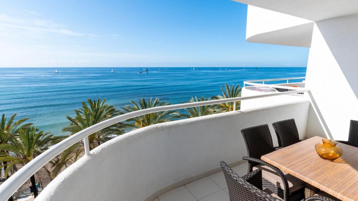 Un balcón con mesa y sillas y el mar. en Hapimag Apartments Marbella, en Marbella