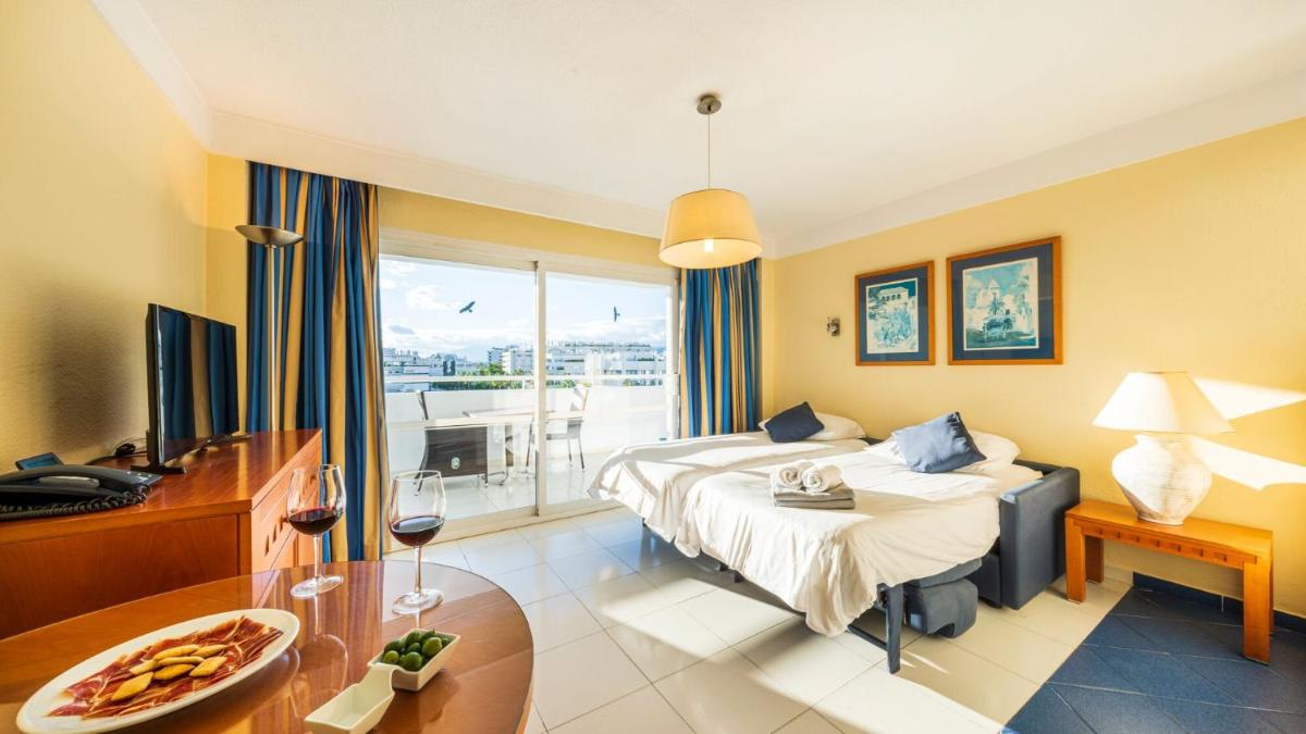 una habitación de hotel con una cama y un balcón en Hapimag Apartments Marbella, en Marbella