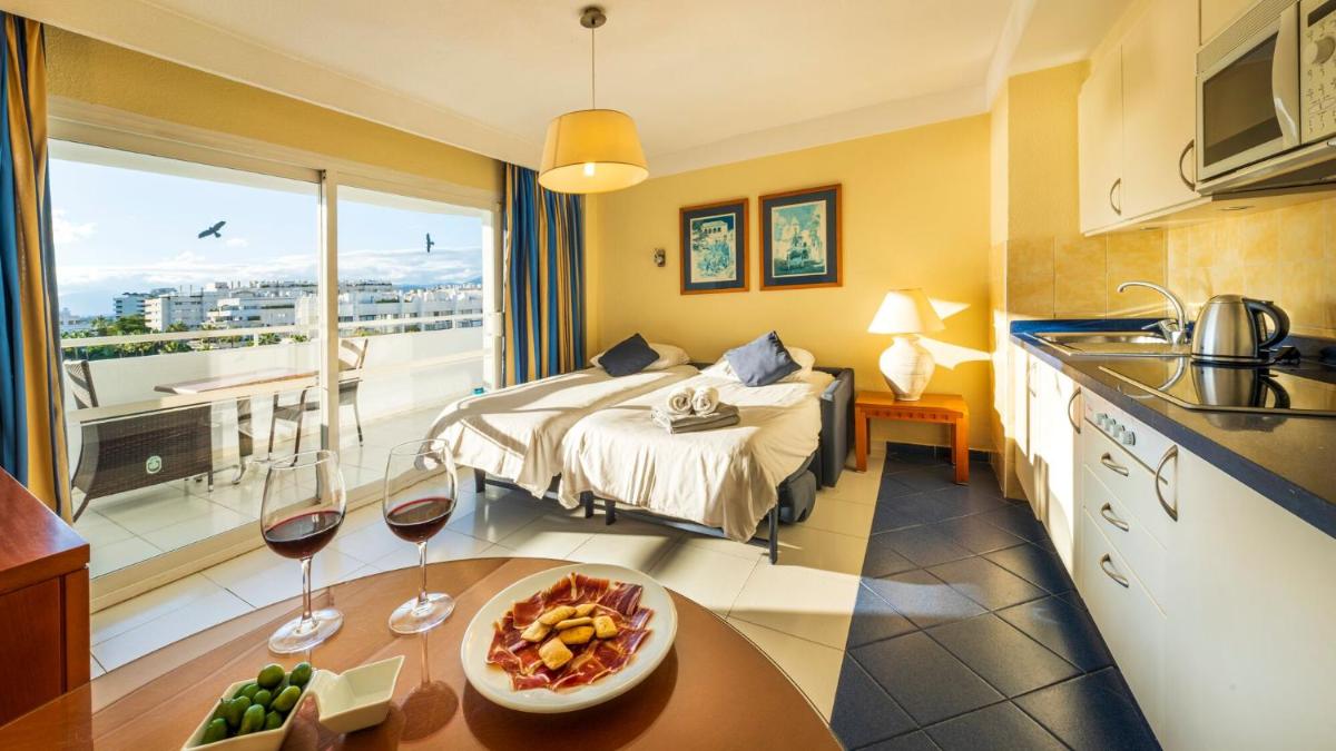 Una habitación de hotel con una cama y una mesa con un plato de comida. en Hapimag Apartments Marbella, en Marbella