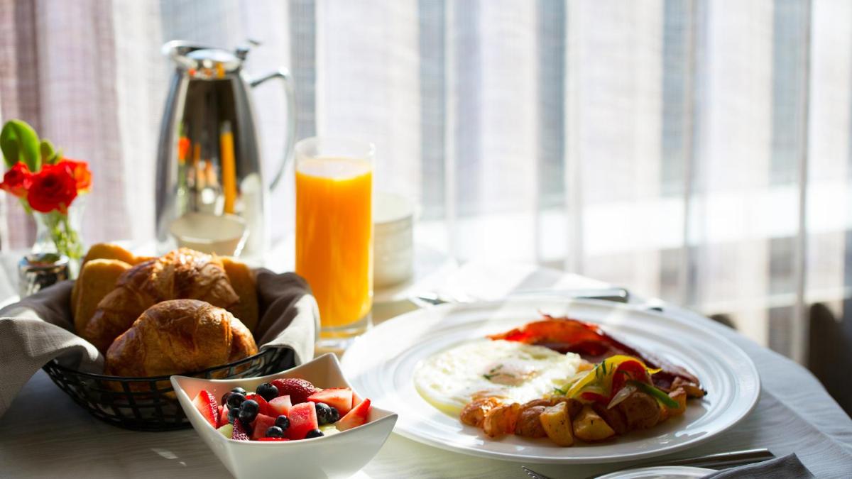 a table with two plates of food and a glass of orange juice at InterContinental Marine Drive Mumbai by IHG in Mumbai