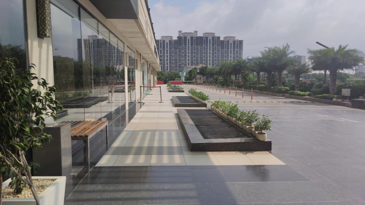 a building with a row of plants on a sidewalk at Holiday Inn Gurugram Sector 90 by IHG in Gurgaon