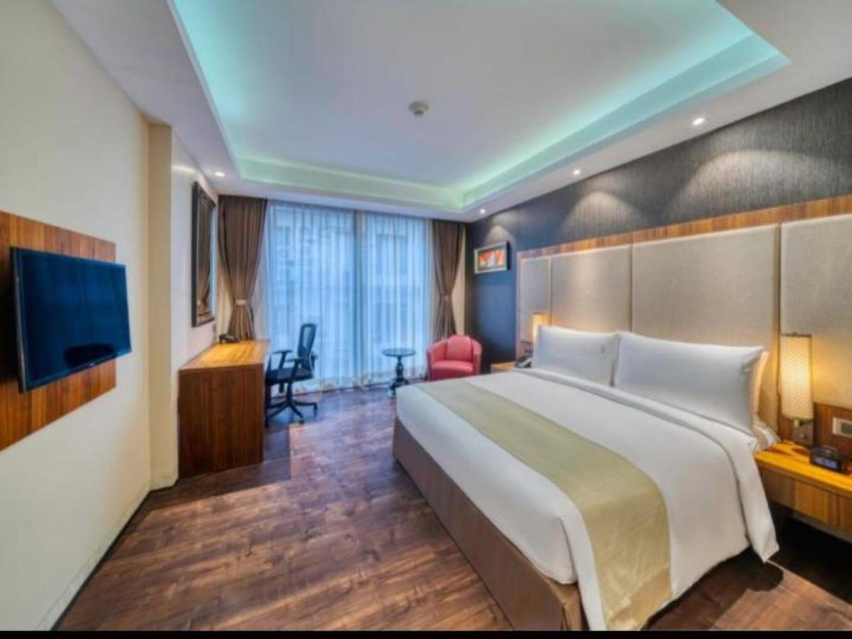 a hotel room with a large bed and a television at Holiday Inn Kolkata Airport by IHG in Kolkata