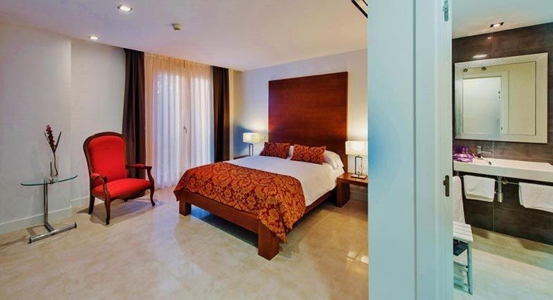 Una habitación de hotel con una cama y una silla roja. en Hotel MedinaSalim, en Medinaceli 77 fotos más