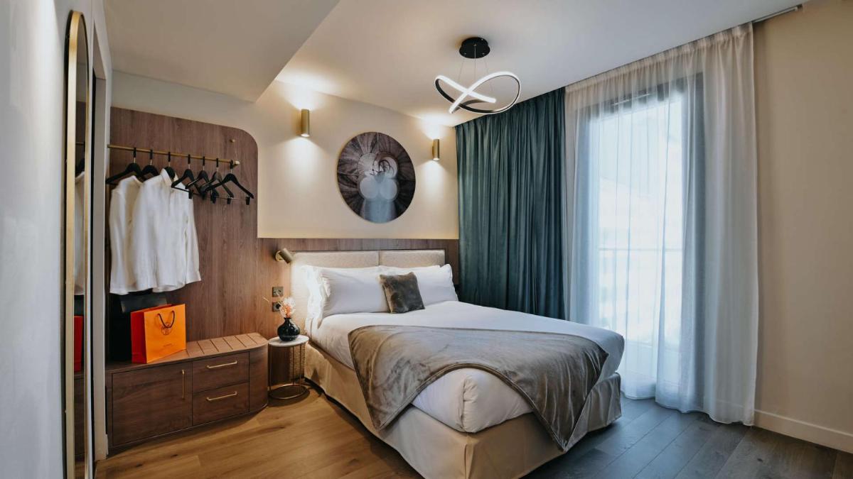 une chambre avec un grand lit et une fenêtre dans l'établissement Keystone Hôtel & Spa, à Lyon