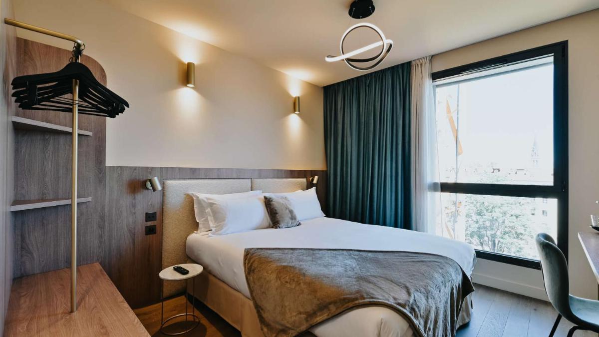 une chambre d'hôtel avec un lit et une fenêtre dans l'établissement Keystone Hôtel & Spa, à Lyon 90 autres photos