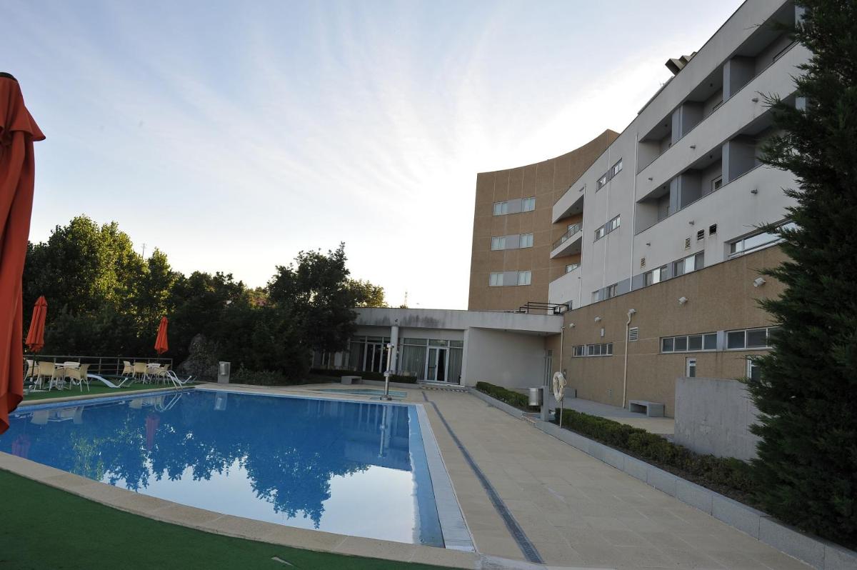 uma grande piscina em frente a um prédio em Hotel Lusitania Congress & Spa na Guarda