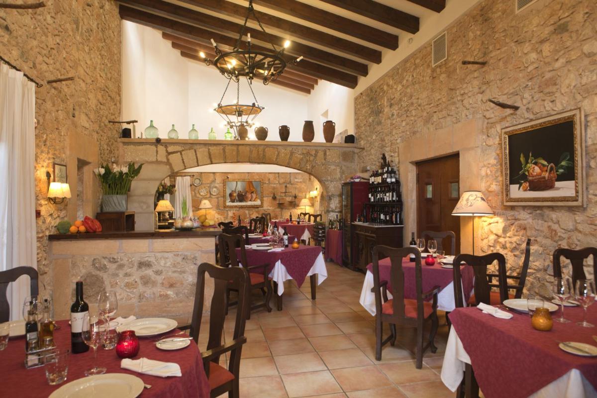 Un restaurante con mesas y sillas en una habitación. en Hotel Son Trobat Wellness & Spa, en Sant Llorenç des Cardassar