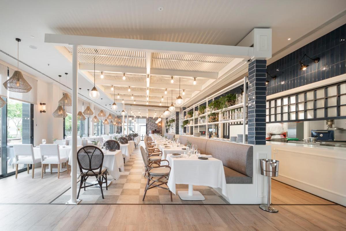 Un restaurante con mesas y sillas blancas y ventanas. en Attica21 Vigo 4 Superior, en Vigo