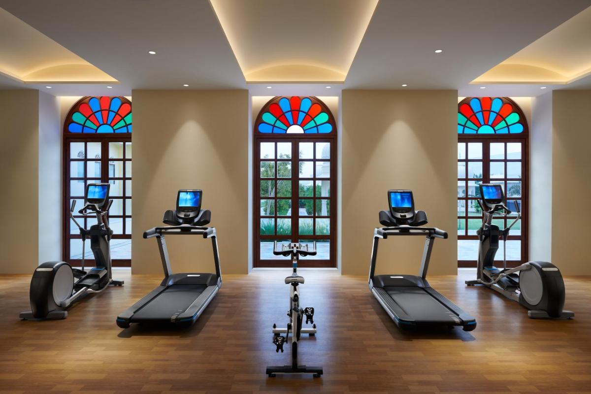 a fitness room with treadmills and stained glass windows at Hyatt Regency Jaipur Mansarovar in Jaipur a fitness room with treadmills and stained glass windows at Hyatt Regency Jaipur Mansarovar in Jaipur