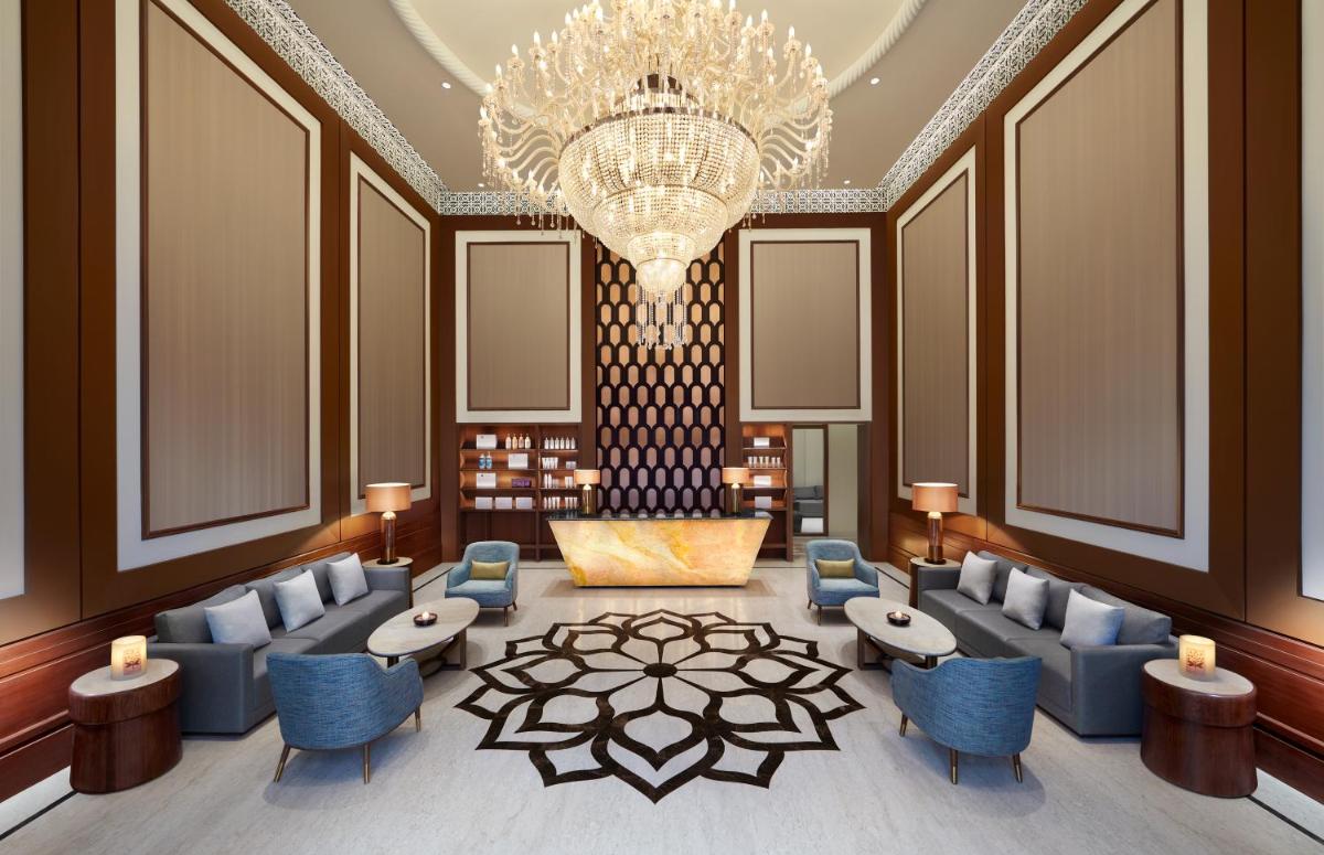 a lobby with blue chairs and a chandelier at Hyatt Regency Jaipur Mansarovar in Jaipur a lobby with blue chairs and a chandelier at Hyatt Regency Jaipur Mansarovar in Jaipur