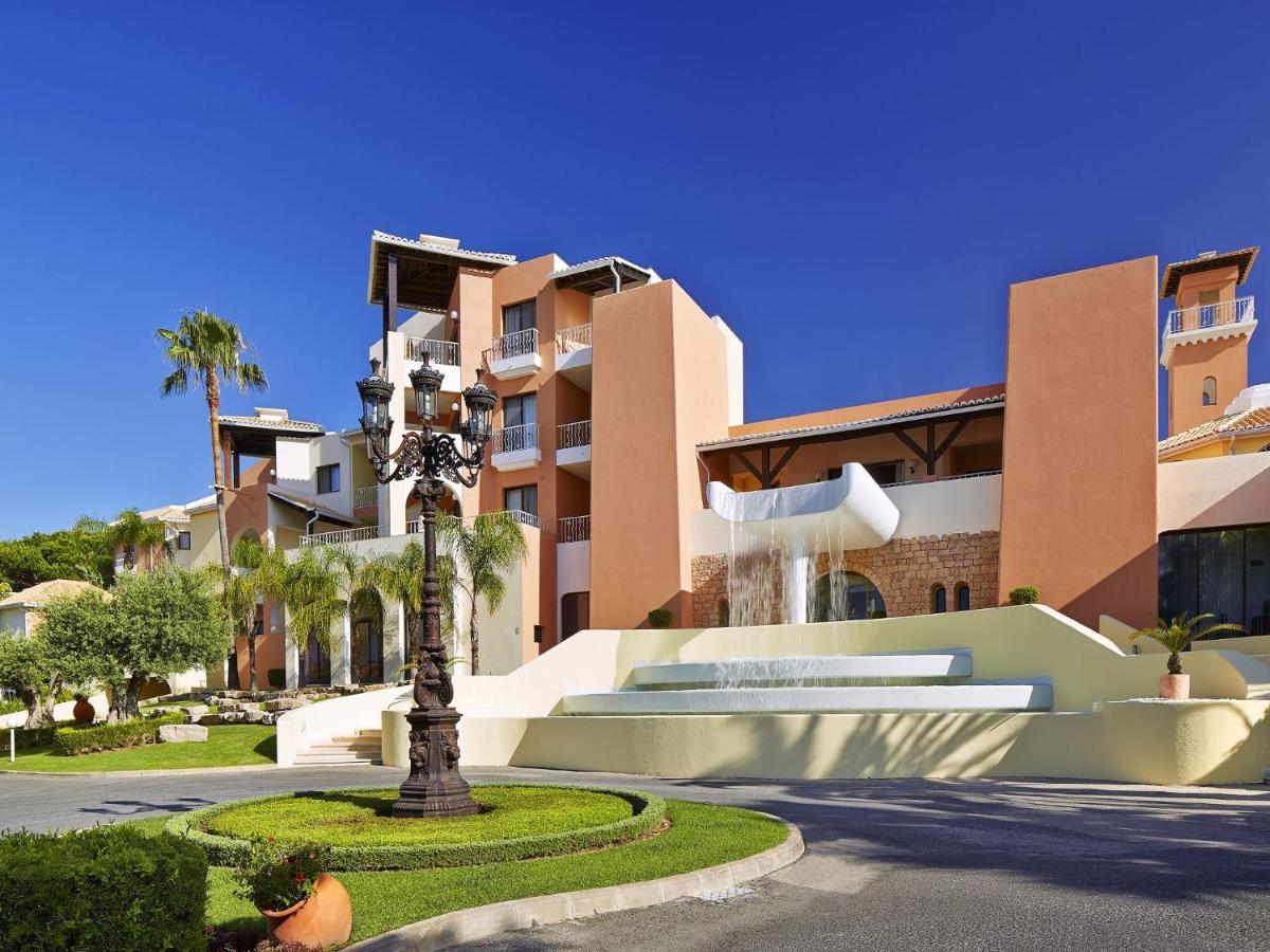 um edifício com uma palmeira em frente a uma rua em Four Seasons Vilamoura em Vilamoura