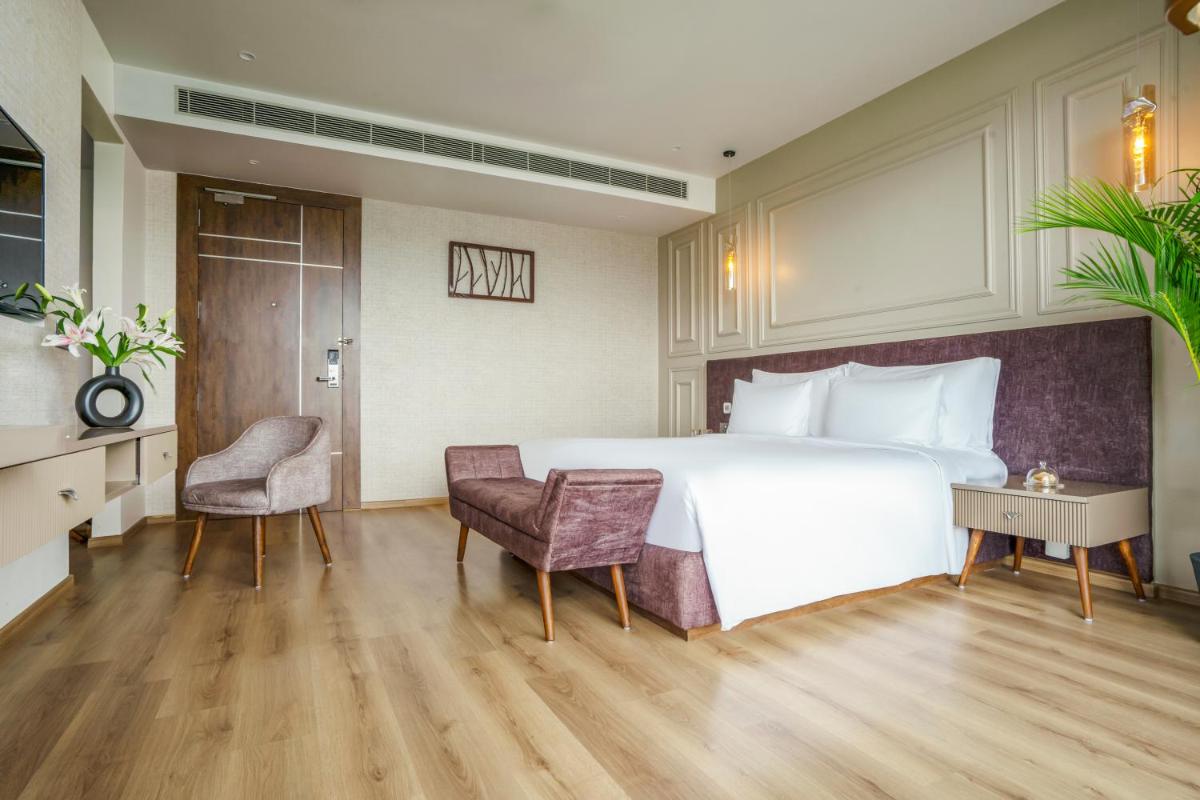 a hotel room with a bed and a desk and chairs at ZANA Lakeview Resort - most scenic lakeside resort in Udaipur