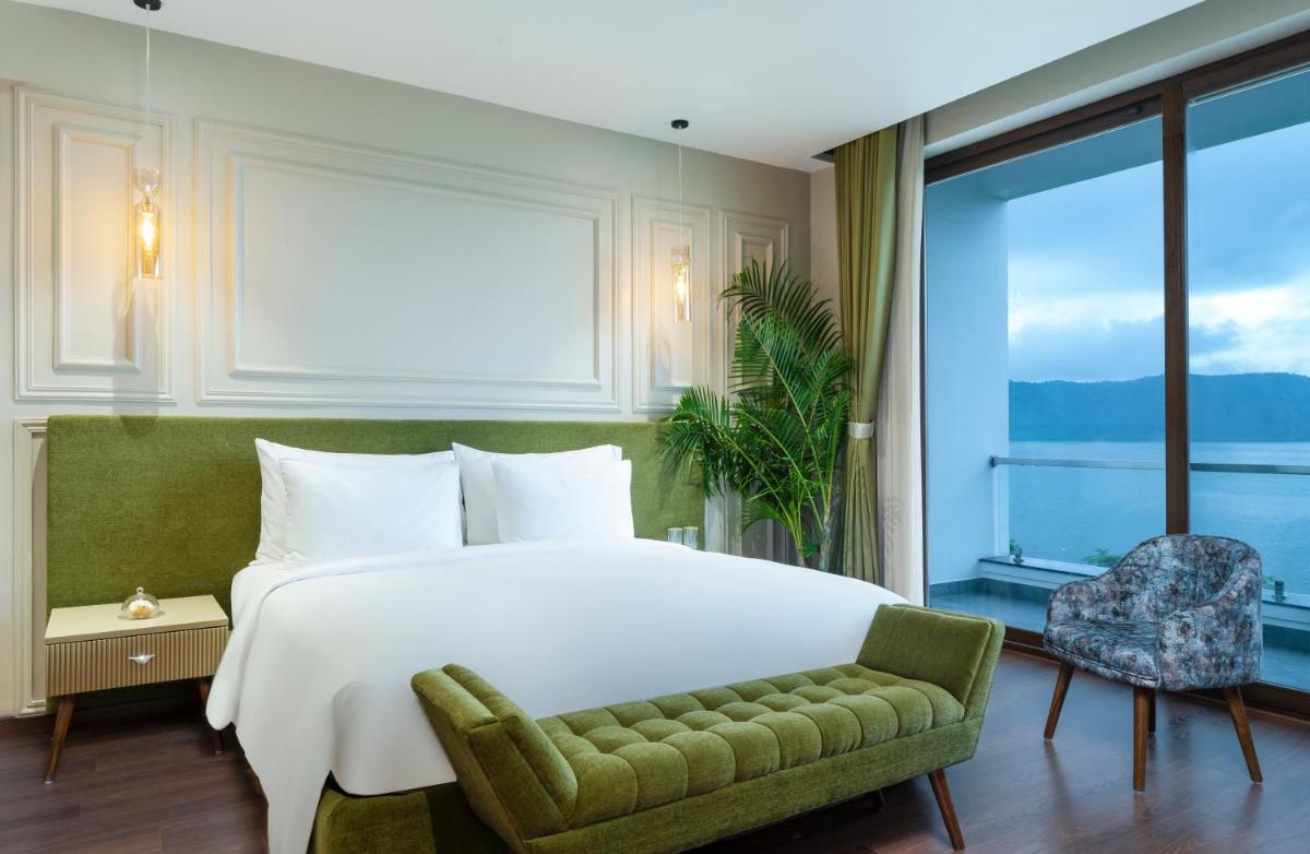 a bedroom with a bed and a large window at ZANA Lakeview Resort - most scenic lakeside resort in Udaipur