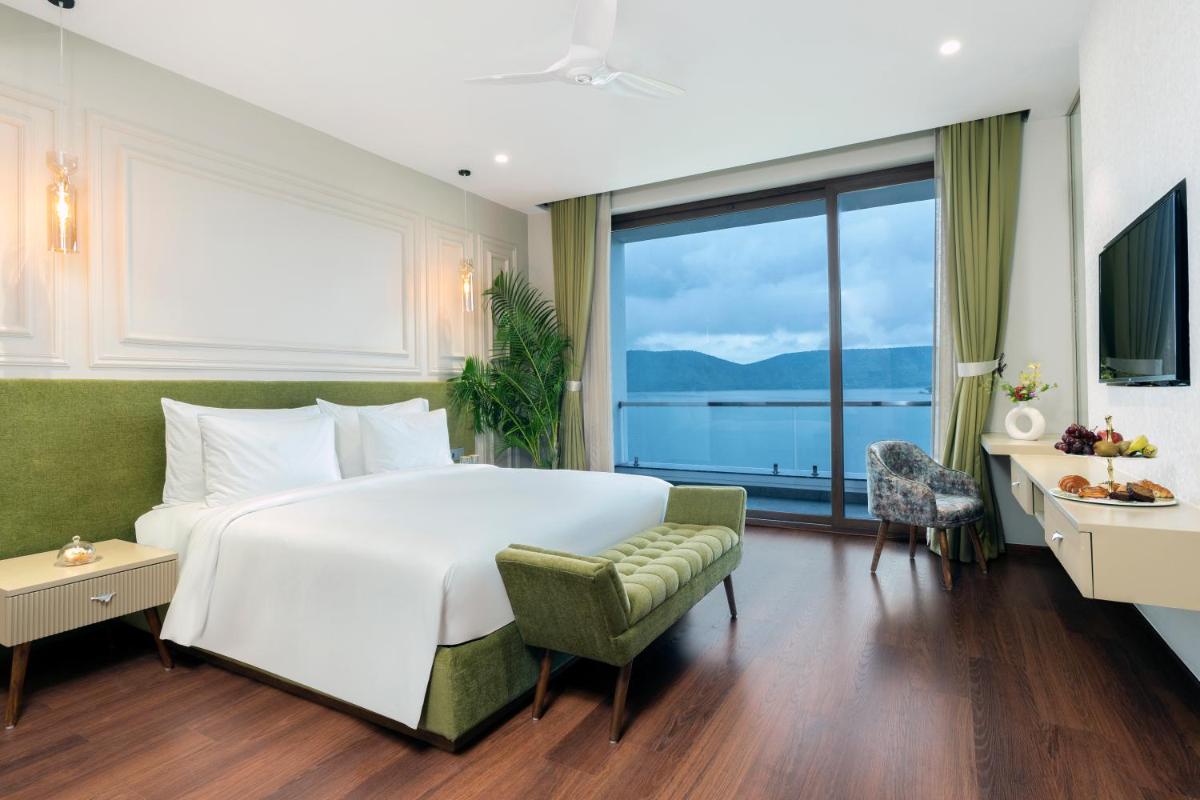 a bedroom with a large bed and a large window at ZANA Lakeview Resort - most scenic lakeside resort in Udaipur