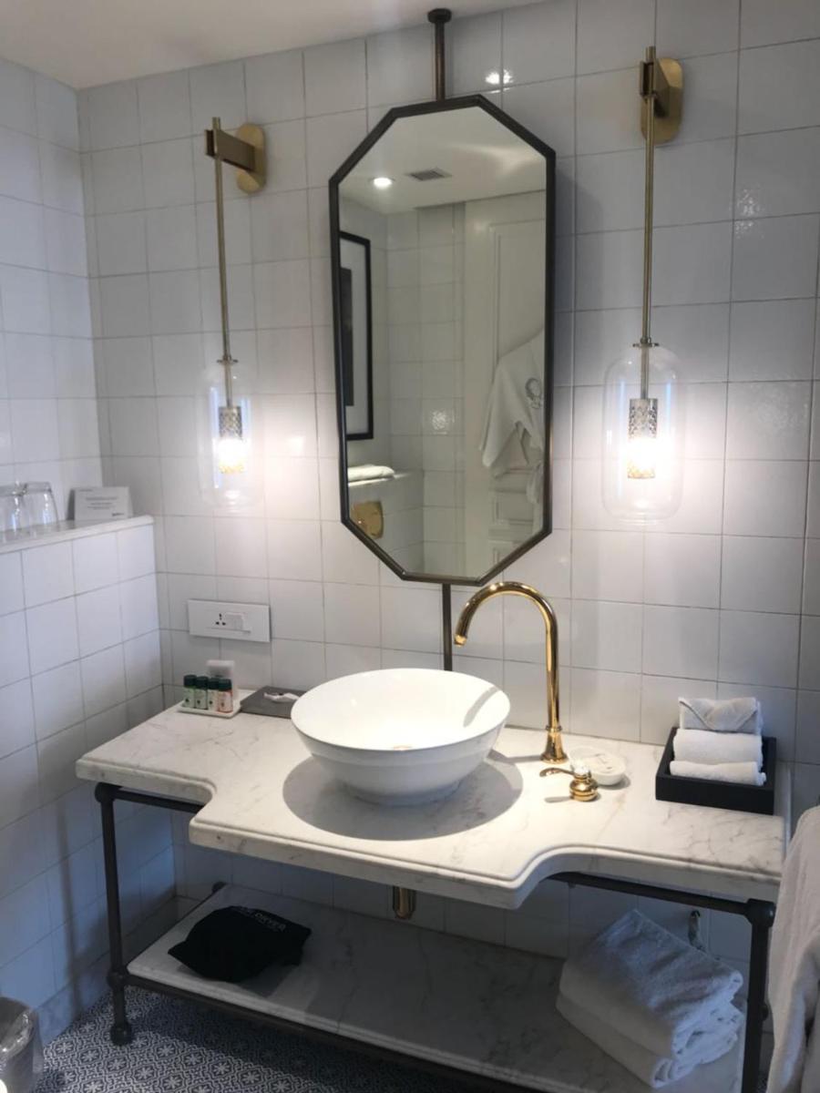 a bathroom with a sink and a mirror on a counter at Radisson Hotel Shimla in Shimla