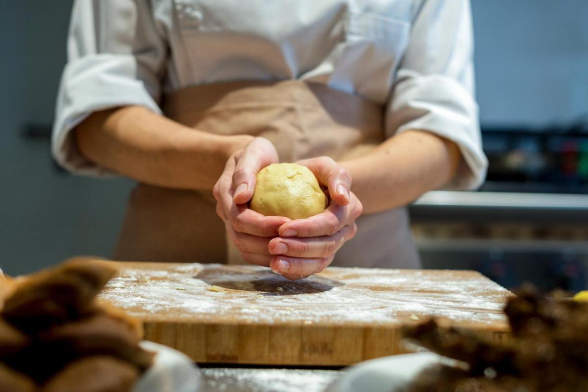 Un chef sosteniendo una manzana en una tabla de cortar. en Can Mascort Eco Hotel, en Palafrugell