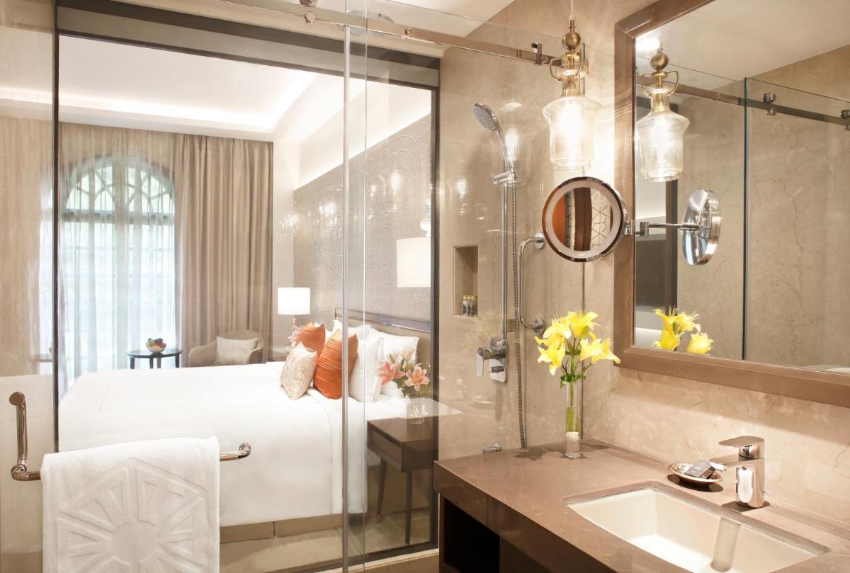 a bathroom with a bed and a shower and a sink at Taj Mahal Lucknow in Lucknow